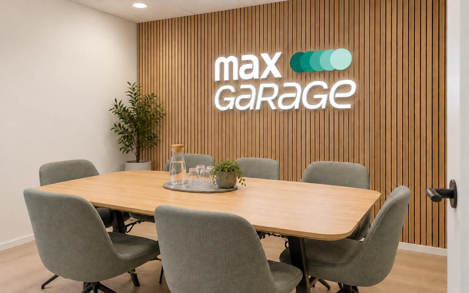 Mødelokale hos Max Garage Silkeborg med egetræsbord, trælameller og Max Garage-skilt